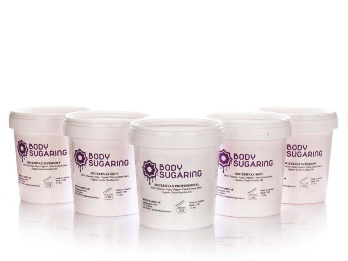 Fem bøtter Bodysugaring sukkervoks i ulike grader på hvit bakgrunn