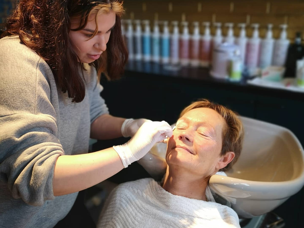 Behandling av overleppe med sukkervoks mens kunden ligger tilbakelent i stolen