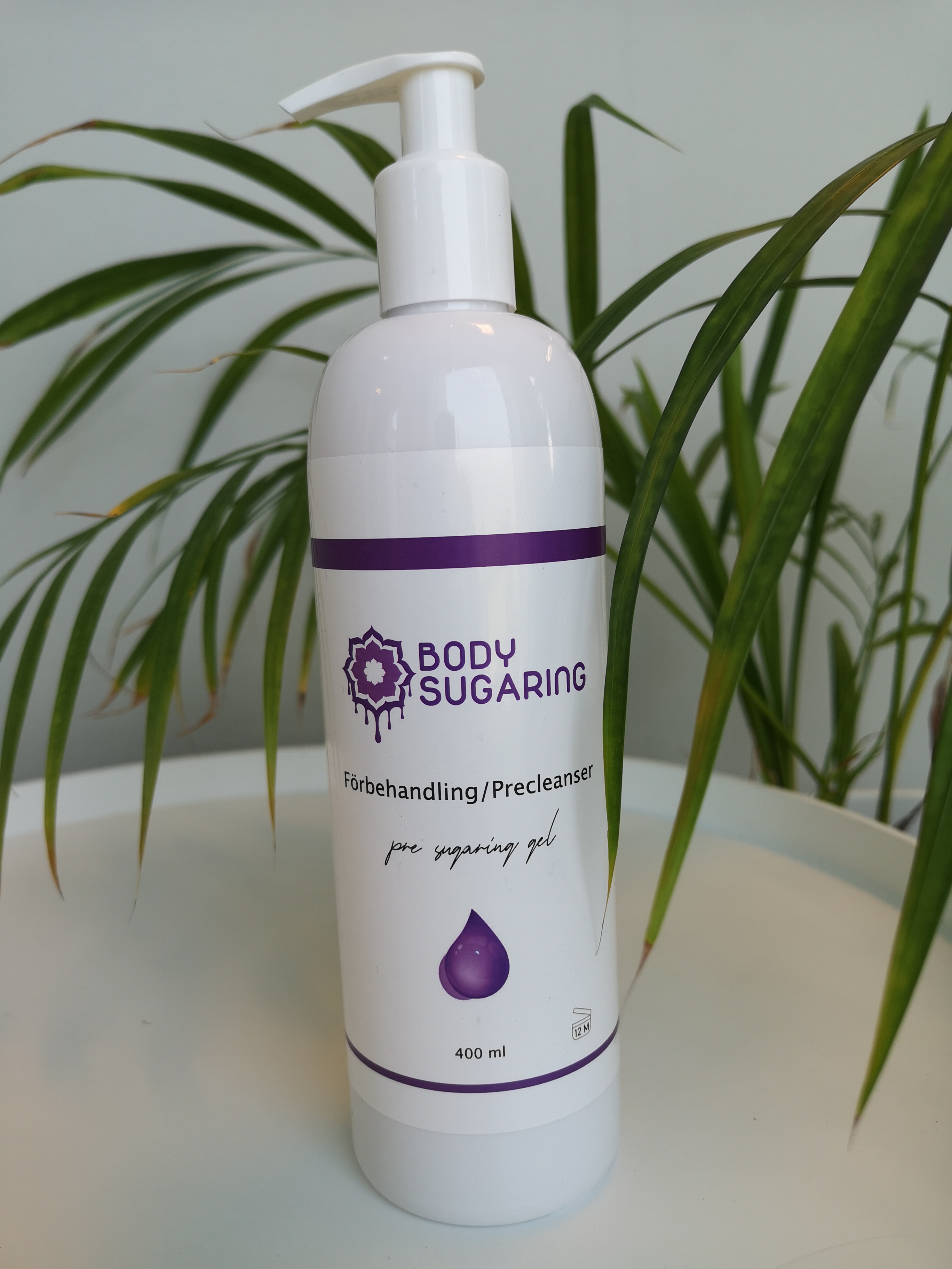 Sprayflaske med Bodysugaring forbehandling på hvit bakgrunn